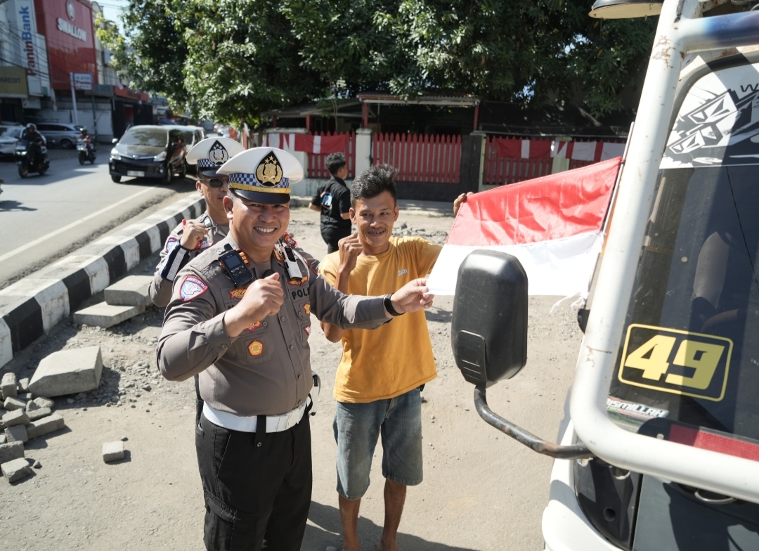 Kasat Lantas Polres Gowa Membagikan Bendera Merah Putih Kepada Pengendara